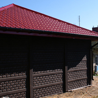 Garaż z dwoma bramami i czerwonym kopertowym dachem